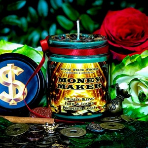 Puede incluir: Un tarro de vela de vidrio verde con una cinta roja y letras doradas que dicen "Money Maker" y "Ritually Blessed, Fixed & Loaded Prosperity Candle". La vela est&aacute; rodeada de monedas de oro, un palo de canela y rosas verdes y rojas.