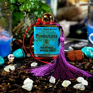 May include: A small bottle of blue and green ritual oil with a purple tassel. The bottle is labeled "Winter Widow Witchery Fortunata Ancestral Ritual Oil".