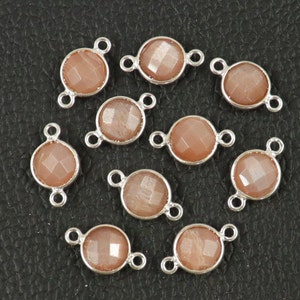 Könnte beinhalten: Zehn silberfarbene Verbindungsanhänger mit pfirsichfarbenen Sunstone-Edelsteinen. Jeder Anhänger hat zwei Ösen zum Anbringen an Schmuck.