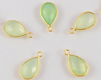 May include: A set of eight green gemstone teardrop pendants with gold-plated jump rings. The pendants are approximately 1 inch long and are perfect for jewelry making.
