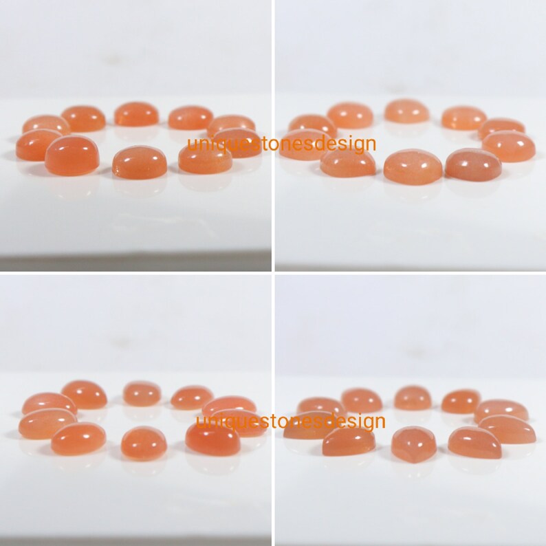 May include: A collection of 12 oval-shaped, peach-coloured gemstones. The stones are arranged in a circle on a white surface.