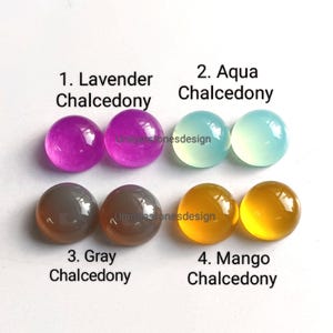 May include: Four pairs of round, polished chalcedony cabochons in lavender, aqua, gray, and mango colors. Each pair is labeled with the color name and "Chalcedony".