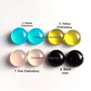 May include: Assortment of eight cabochon gemstones, including paraiba chalcedony, yellow chalcedony, pink chalcedony, and black onyx. Each gemstone is displayed in pairs on a white surface.