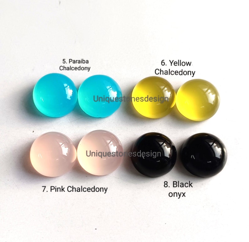 May include: Assortment of eight cabochon gemstones, including paraiba chalcedony, yellow chalcedony, pink chalcedony, and black onyx. Each gemstone is displayed in pairs on a white surface.