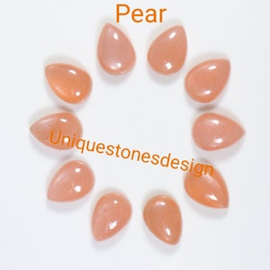 May include: Ten pear-shaped, light orange sunstone cabochons. The stones are arranged in a circle on a white background. The text "Pear" is at the top of the image and "Uniquestonesdesign" is at the bottom.