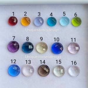 May include: A collection of 16 faceted gemstones in various colors, including red, orange, blue, green, purple, and clear. The gemstones are arranged in rows of four, numbered 1 through 16. The image includes the text "Uniquestonesdesign".
