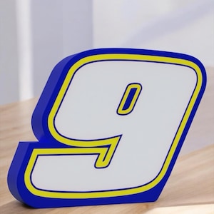 May include: A blue and yellow 3D number nine. The number is made of foam and has a white interior.