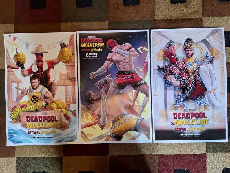 May include: Three movie posters for the film "Deadpool & Wolverine: Loo Wa." The posters feature different scenes from the film, including a fight scene, a scene with Deadpool and Wolverine in traditional Thai clothing, and a scene with Deadpool and Wolverine in a jungle setting. The posters are all in the same style, with a red and black color scheme and a bold font.