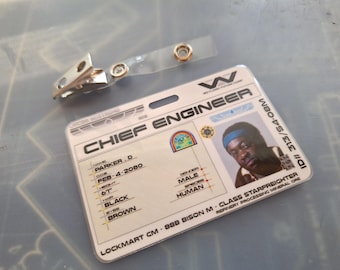 Puede incluir: Una tarjeta de identificación de plástico blanca con el texto "Chief Engineer" y una foto de un hombre. La tarjeta también incluye el nombre "Parker. D", la fecha "Feb-4-2080" y el texto "Lockmart CM 888 Bison M-Class Starfreighter Refinery Processing Mineral Ore".
