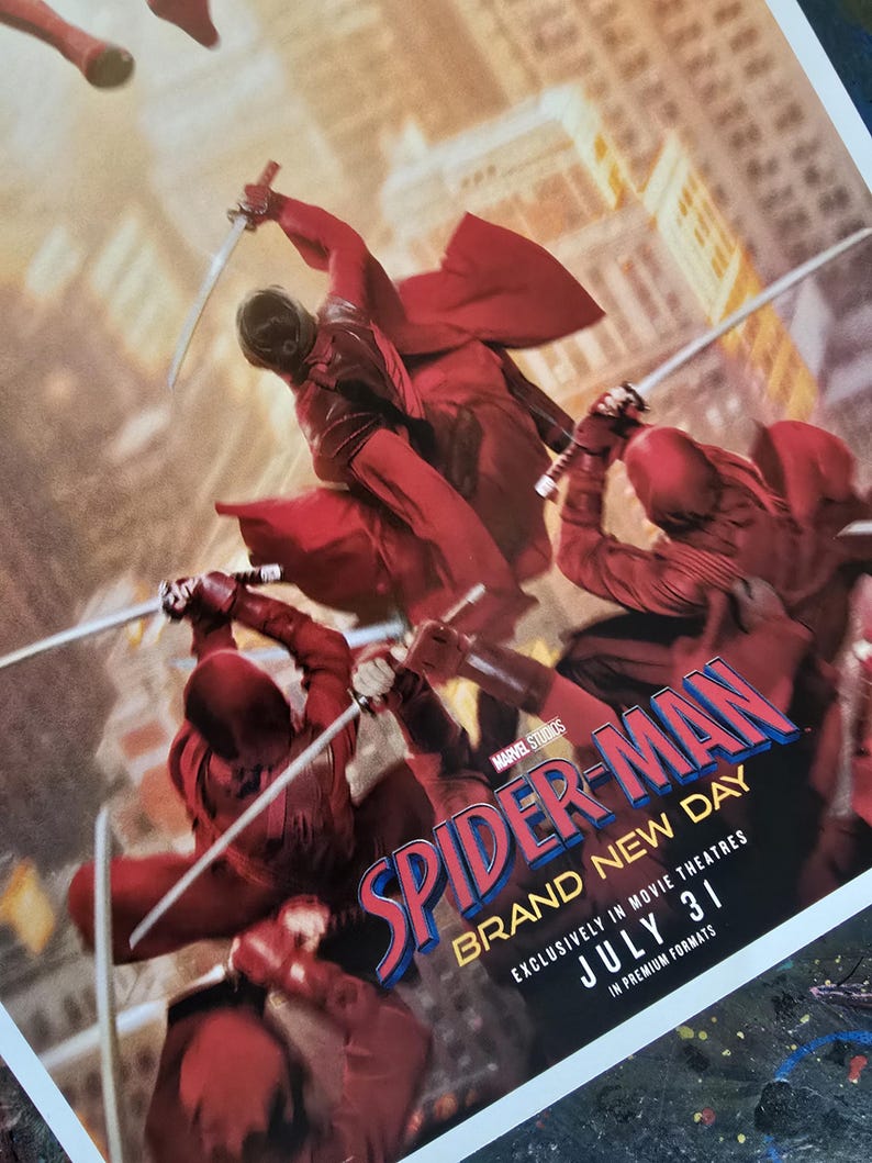 K&ouml;nnte beinhalten: Ein Filmplakat f&uuml;r Spider-Man: Brand New Day. Das Bild zeigt Figuren in roten Kost&uuml;men mit Schwertern vor einem Stadtpanorama. Der Titel ist in gro&szlig;en, stilisierten Buchstaben gehalten, mit dem Ver&ouml;ffentlichungsdatum 31. Juli.