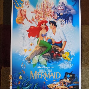 May include: A vintage movie poster for the Disney film "The Little Mermaid". The poster features Ariel, the mermaid princess, with her human prince, Eric. King Triton, Ursula the sea witch, and Flounder are also featured on the poster. The poster is set against a blue background with a castle in the background.