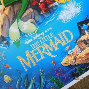 May include: A vintage VHS tape case for the Disney movie The Little Mermaid. The case features a colorful illustration of Ariel, the mermaid princess, with a blue background and a treasure chest filled with gold coins.