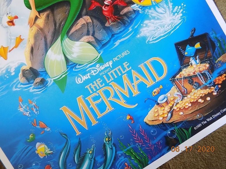 May include: A vintage VHS tape case for the Disney movie The Little Mermaid. The case features a colorful illustration of Ariel, the mermaid princess, with a blue background and a treasure chest filled with gold coins.