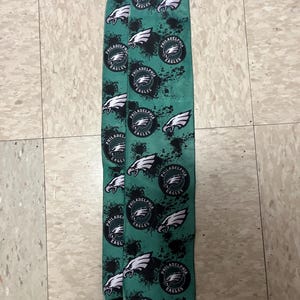 K&ouml;nnte beinhalten: Ein Paar gr&uuml;n-schwarze Socken mit einem sich wiederholenden Muster des Philadelphia Eagles-Logos. Das Logo ist ein wei&szlig;er Adler mit schwarzem Umriss und den Worten "Philadelphia Eagles" in einem schwarzen Kreis.