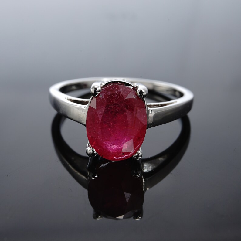 Pu&ograve; includere: Un anello d'argento con una grande pietra rossa di forma ovale.