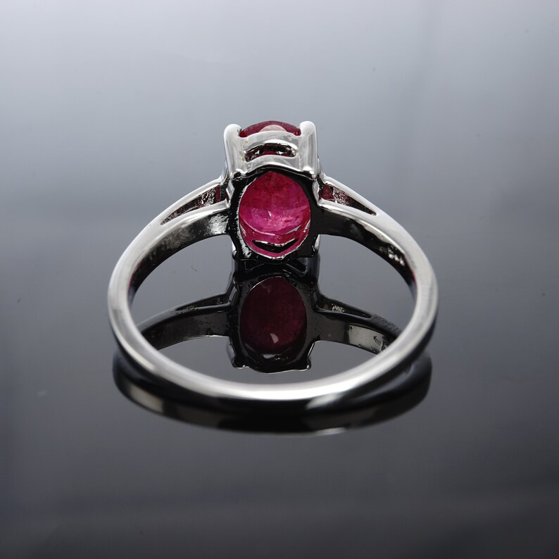 Pu&ograve; includere: Un anello d'argento con una grande pietra rossa di forma ovale.