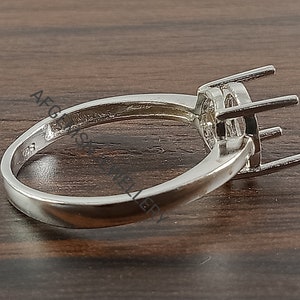 May include: Silver ring setting with a round bezel for a gemstone. The ring is plain and has a smooth band.