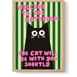 Può includere: Una stampa artistica incorniciata con uno sfondo a righe verdi e bianche. La stampa presenta un'illustrazione di un gatto nero con il testo "WELCOME TO THE BATHROOM" e "THE CAT WILL BE WITH YOU SHORTLY" in rosa.