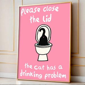 May include: A pink poster with a black cat in a toilet bowl. The text on the poster reads "Please close the lid the cat has a drinking problem."
