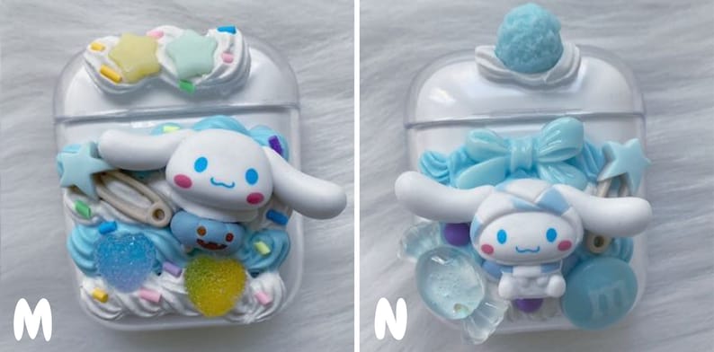 May include: Two white Airpod cases decorated with blue and white 3D characters, candy, and sprinkles. One case features a blue bow and the other features a safety pin.