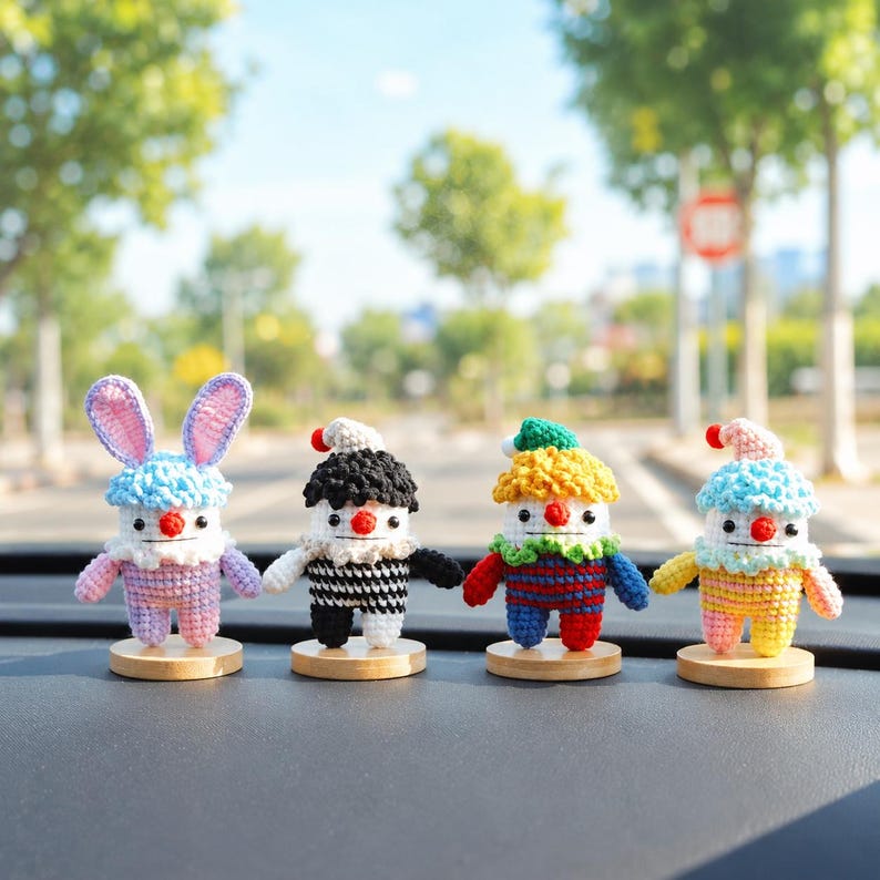 May include: Four colorful, handmade crochet figures with round wooden bases. The figures include a bunny with blue ears, a clown with a black and white outfit, and two other clowns with different colored outfits. Each figure has a red nose and a small hat.