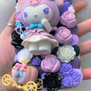 Puede incluir: Una funda de tel&eacute;fono rosa y morada decorada con un personaje en 3D, flores y un carruaje. El personaje es un conejo blanco con un vestido rosa y un lazo azul. Las flores son en tonos de rosa, morado y negro. El carruaje es dorado y rosa.