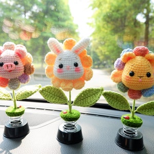 Puede incluir: Tres adornos de cabeza de animal de crochet en bases con resorte. Los adornos son un cerdo rosa, un conejito blanco y un león amarillo. Cada animal está rodeado de pétalos de flores de crochet.