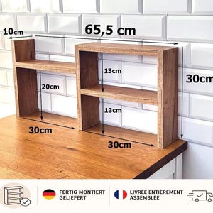 Può includere: Un organizer da scrivania in legno a due livelli con diversi scomparti. L'unità misura 65,5 cm di larghezza totale, 30 cm di altezza e 10 cm di profondità. I ripiani hanno spazi verticali di 20 cm e 13 cm, con una base di 30 cm.