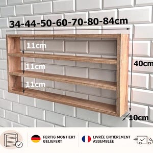 Könnte beinhalten: Ein hellbraunes Wandregal aus Holz mit drei Ebenen. Das Regal hat eine Gesamthöhe von 40 cm, eine Tiefe von 10 cm und drei Fächer mit jeweils 11 cm Abstand. Verfügbare Breiten: 34, 44, 50, 60, 70, 80 und 84 cm. Das Regal wird fertig montiert geliefert.