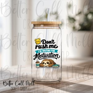 May include: A clear glass tumbler with a bamboo lid and a white straw. The tumbler features a graphic of a sloth, coffee cup, and book, with the text "Don't rush me I'm waiting for Motivation."