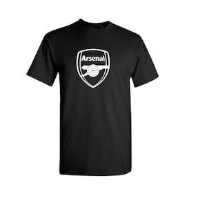 May include: Black t-shirt with the Arsenal logo printed in white. The logo is a shield shape with the word "Arsenal" above a cannon. The shirt has a crew neck and short sleeves.