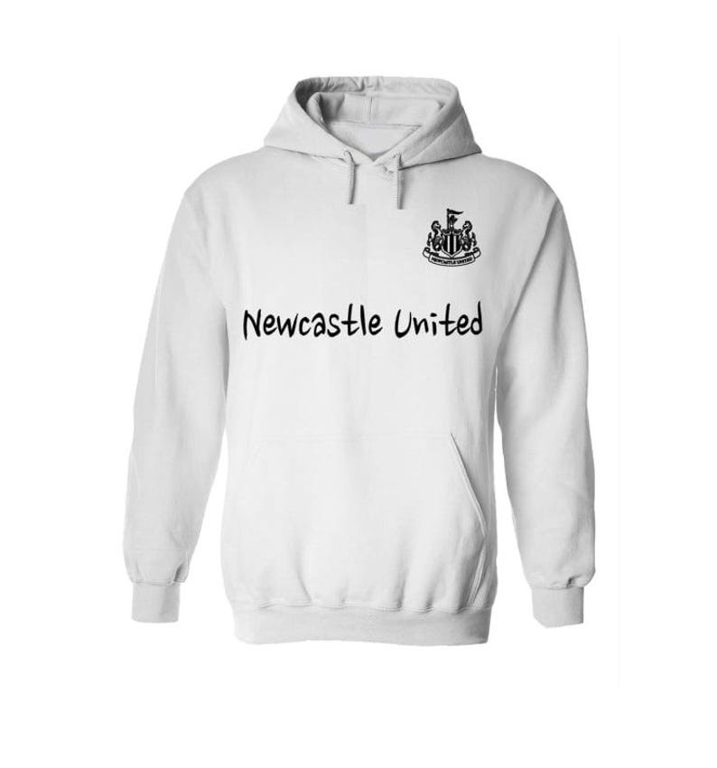 May include: White hooded sweatshirt with the text "Newcastle United" in black, along with a team crest on the upper right chest. The sweatshirt has a front pocket and a drawstring hood.