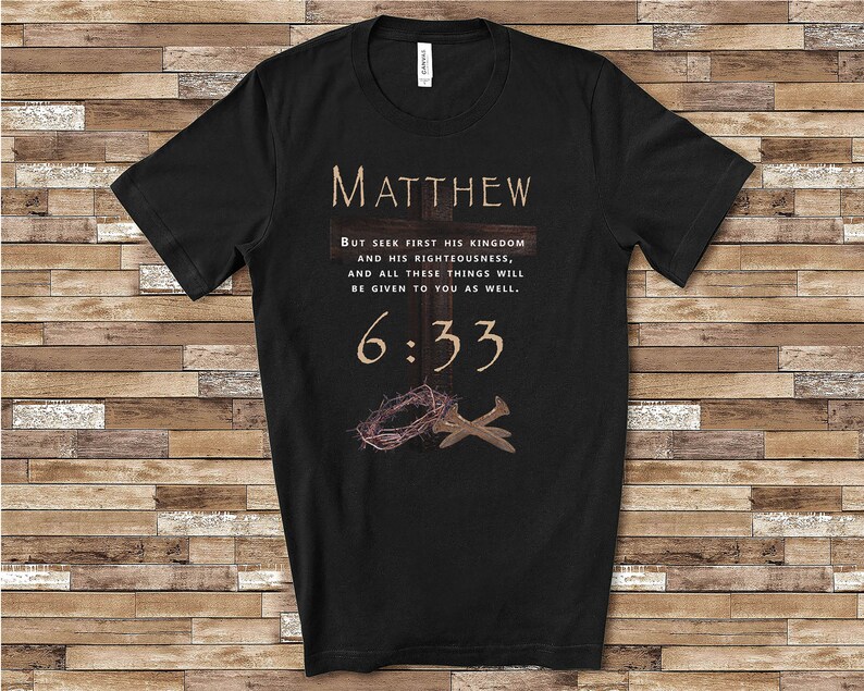 May include: Black t-shirt with a brown cross and a crown of thorns. The text "MATTHEW 6:33" is printed on the shirt. The text reads "But seek first his kingdom and his righteousness, and all these things will be given to you as well."