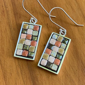 Peut inclure: Une paire de boucles d'oreilles en argent avec des carreaux de mosaïque rectangulaires dans des tons de brun, beige et vert.