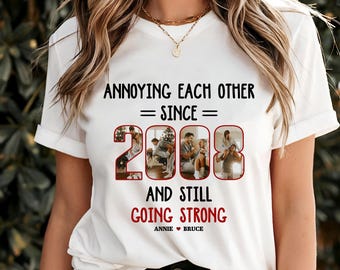 Puede incluir: Camiseta blanca con el texto "Annoying Each Other = Since = 2008 And Still Going Strong Annie ♥ Bruce" en negro y rojo. El año 2008 está formado por cuatro fotos de una pareja.