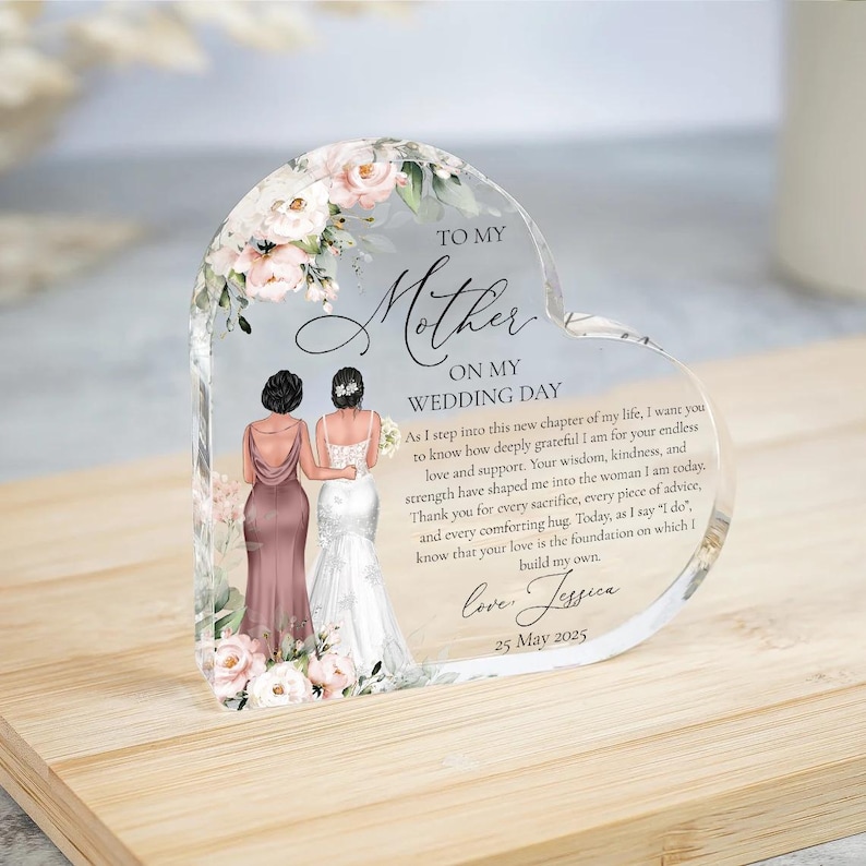 Puede incluir: Un recuerdo de vidrio en forma de coraz&oacute;n con un dise&ntilde;o floral y un mensaje para una madre en el d&iacute;a de la boda de su hija. El mensaje dice: "A mi madre, en mi d&iacute;a de boda. Al entrar en este nuevo cap&iacute;tulo de mi vida, quiero que sepas lo profundamente agradecida que estoy por tu amor y apoyo infinitos. Tu sabidur&iacute;a, amabilidad y fortaleza me han moldeado para convertirme en la mujer que soy hoy. Gracias por cada sacrificio, cada consejo y cada abrazo reconfortante. Hoy, al decir "s&iacute;", s&eacute; que tu amor es la base sobre la que construyo la m&iacute;a. Con amor, Jessica 25 de mayo de 2025."