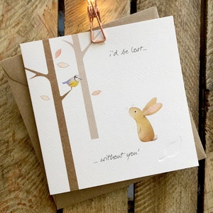 Carte de vœux mettant en vedette un lapin et une mésange bleue dans la forêt, magnifiquement illustrée. La légende dit « Je serais perdu sans toi »