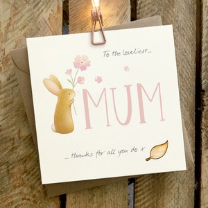 Biglietto per la mamma, per il compleanno, per la festa della mamma con un riccio, un uccello e dei fiori. La carta ha un attacco a foglia di legno