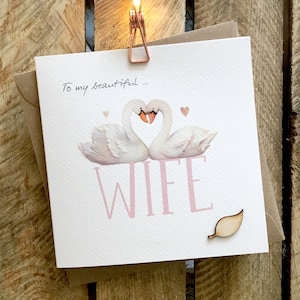 Cartão de Dia das Mães para Esposa, Cartão de Aniversário de Esposa com dois cisnes e grande legenda de Esposa. O cartão tem um anexo de folha de madeira