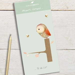Puede incluir: Bloc de notas magnético verde claro con una ilustración de un búho posado en una rama. El bloc de notas tiene el texto "GingerBetty Magnetic Notepad ..." en la parte superior y "... To do list" en la parte inferior. También hay dos abejas ilustradas.