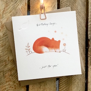 Carte d’anniversaire mettant en vedette un renard mignon et un petit renard blotti en dormant, magnifiquement illustrée. La légende se lit comme suit: « Câlins d’anniversaire, juste pour vous »