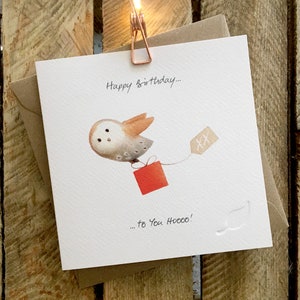 Carte d’anniversaire mettant en vedette la chouette effraie volante portant un cadeau, magnifiquement illustrée. La légende se lit comme suit: « Joyeux anniversaire à toi Hooo!