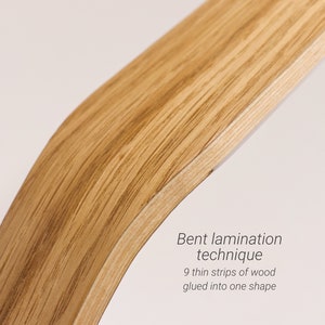May include: Close-up of a curved piece of wood, showing the grain and texture. The text "Bent lamination technique 9 thin strips of wood glued into one shape" is visible below the wood.