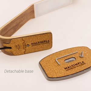 May include: A wooden desk lamp with a cork base. The lamp has a USB port and a detachable base. The base has a screw and a small Allen wrench. The lamp is labeled "MALSIMPLA HANDMADE IN EUROPE".