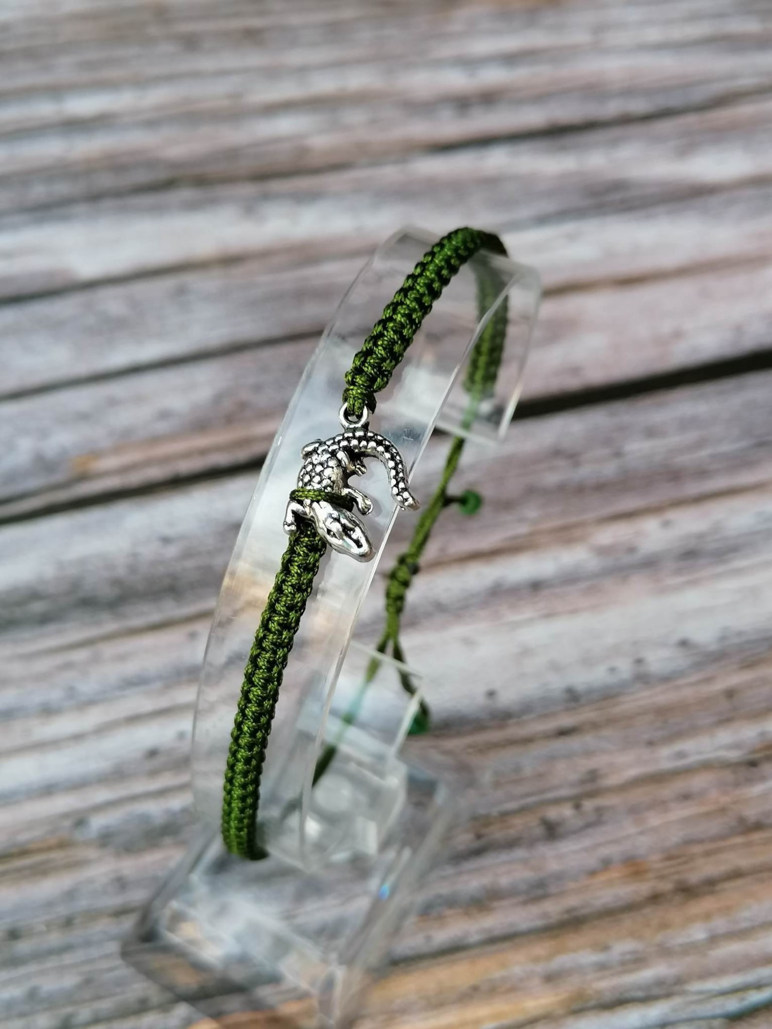 green thread bracelet with silver alligator in center