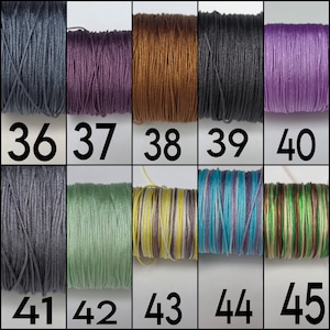 May include: A grid of ten spools of thread labeled 36 through 45. The colors include dark gray, deep purple, copper, black, light purple, medium gray, sage green, yellow and white stripes, blue and purple stripes, and green and brown stripes.