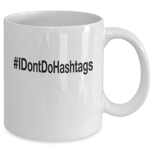 以下が含まれることがあります： 黒い文字で「#IDontDoHashtags」と書かれた白いセラミック製のコーヒーカップです。
