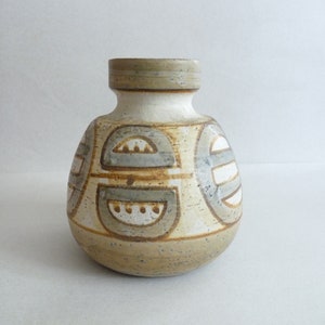 May include: A ceramic vase with a rounded body and a geometric pattern in shades of brown, white, and gray.