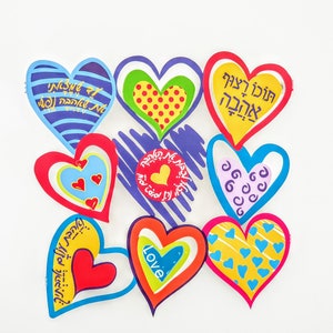 Puede incluir: Una colecci&oacute;n de ocho recortes de papel en forma de coraz&oacute;n de colores con texto en hebreo y dise&ntilde;os. Los corazones est&aacute;n dispuestos en c&iacute;rculo sobre un fondo blanco. El texto en los corazones incluye "Love", "Feliz cumplea&ntilde;os" y otras frases en hebreo.