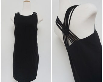 May include: A black sleeveless dress with a criss-cross strap detail in the back.